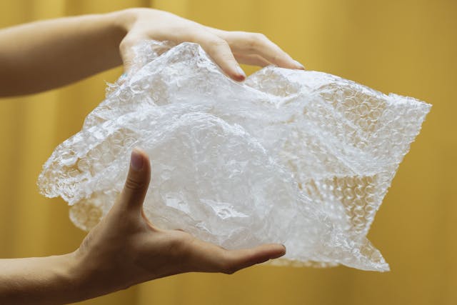 Close-up of person’s hand holding some bubble wrap.