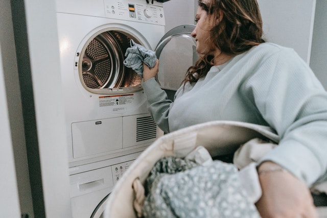 woman doing laundry to save water at your rental property