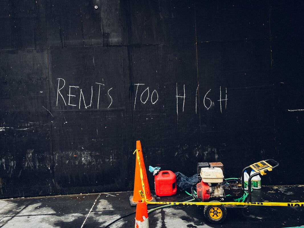 A sign on the wall that reads: rent’s too high.