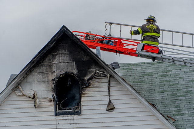 Fireman inspecting a burned house.