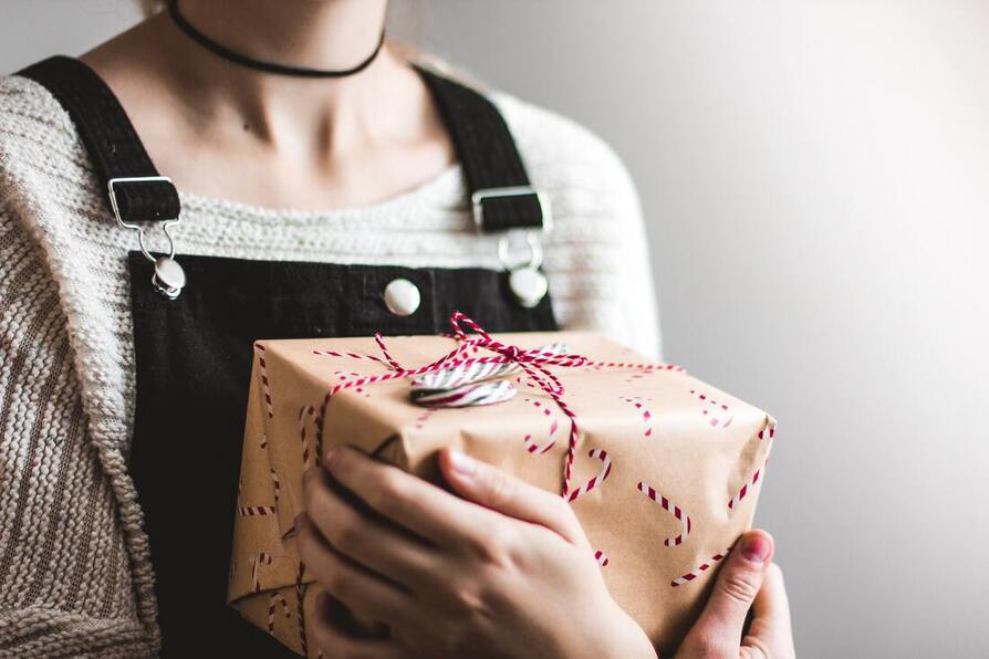 A girl carrying a wrapped gift.