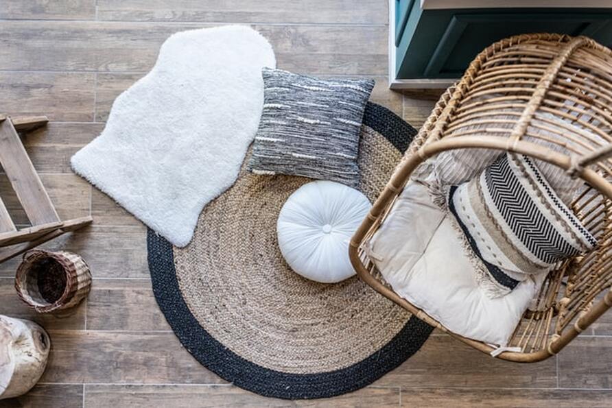 Two small rugs, a couple of throw pillows, and a rattan chair from above