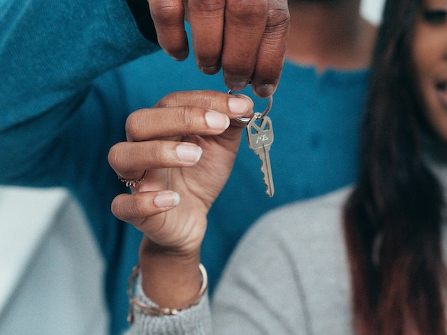 people holding the key to a house