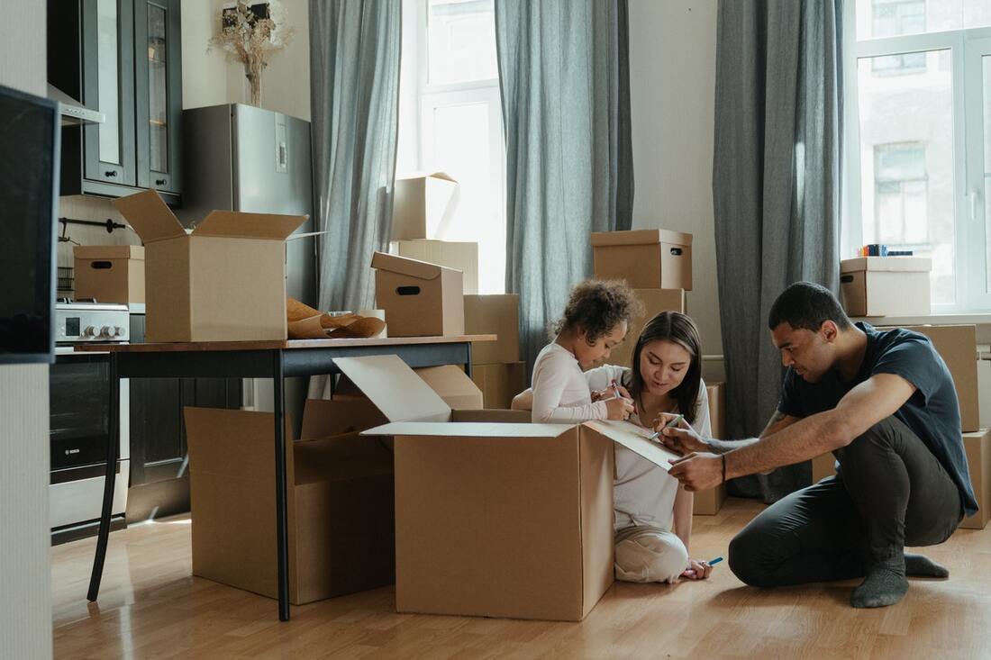A Reno family packing boxes thinking whether it's better to move yourself or hire movers