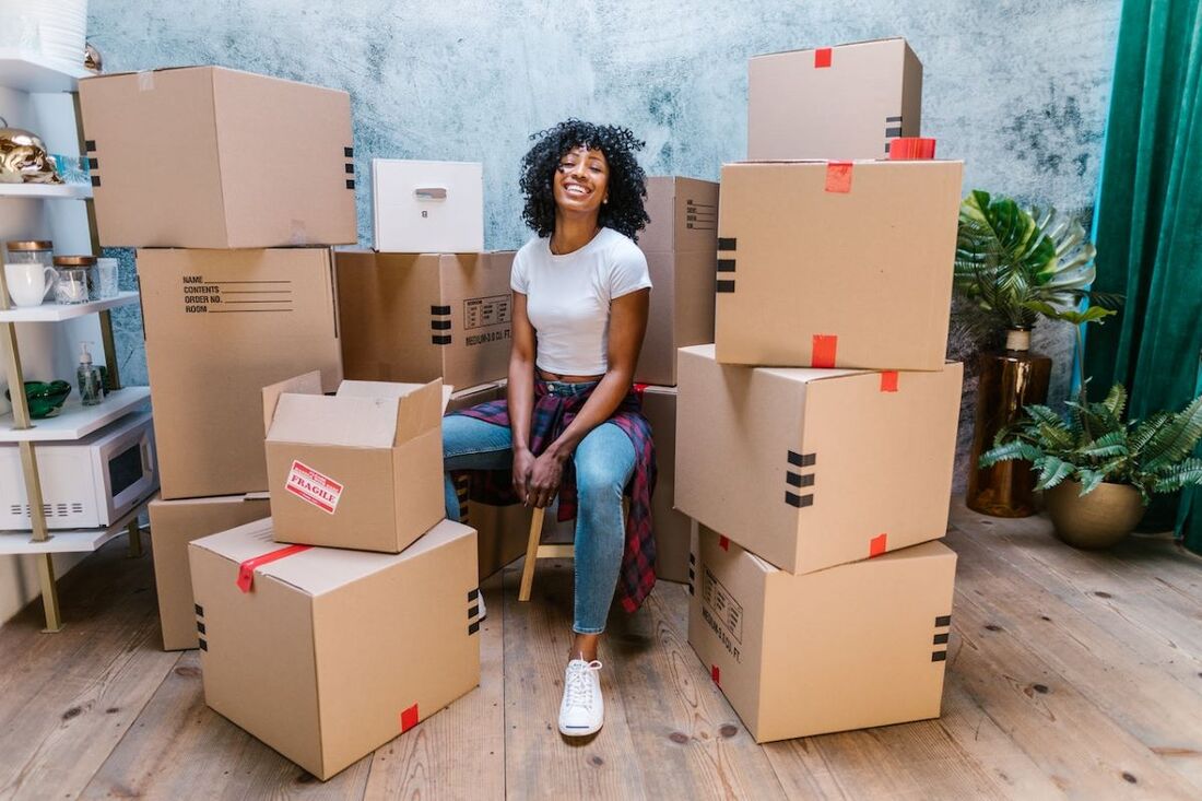 A girl surrounded by moving boxes.