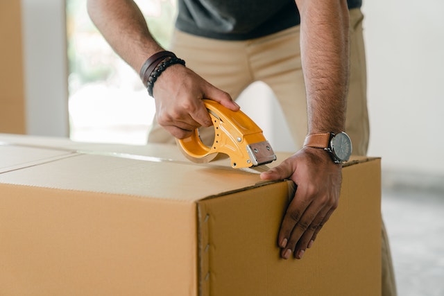 A man taping a box
